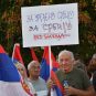 Čovek sa transparentom na skupu protiv blokada