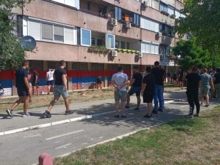 Muškarci u crnom crtaju trobojke po zgradama
