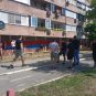 Muškarci u crnom crtaju trobojke po zgradama