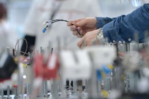 Čovek u fabrici sa kablom u ruci