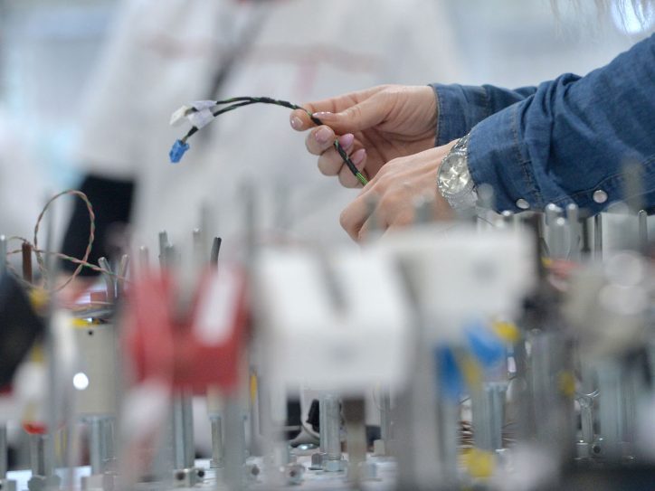 Čovek u fabrici sa kablom u ruci