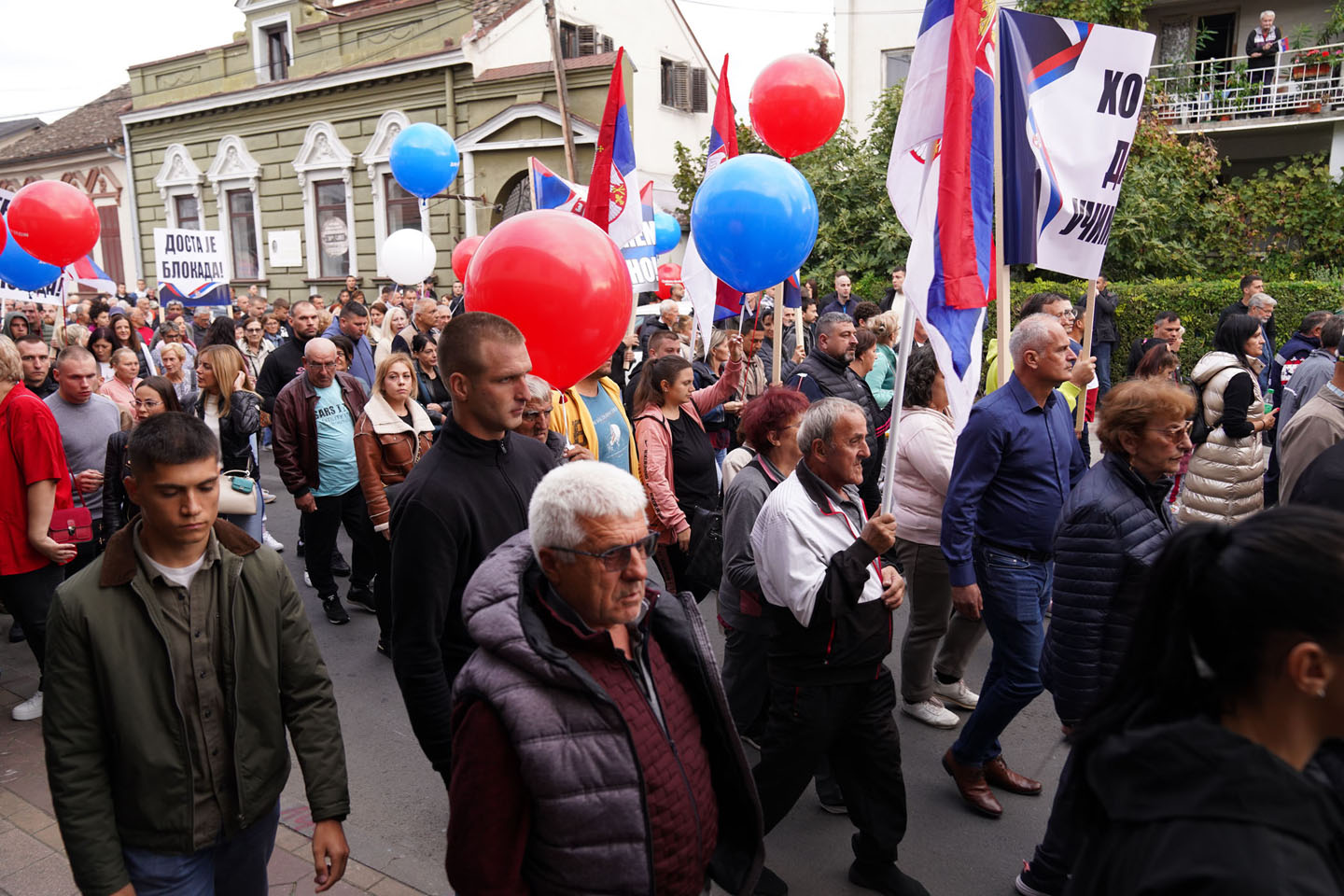 Građani na ulici sa balonima i zastavama na skupu protiv blokada