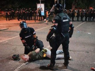 Policija privodi demonstranta na protestu