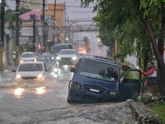 Ljudi napuštaju automobil na u ulici poplavljenoj kišama izazvanim tropskom olujom Melisa u Santo Domingu, Dominikanska Republika
