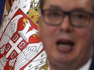 Zamagljeni portret Aleksandra Vučića pred grbom Srbije