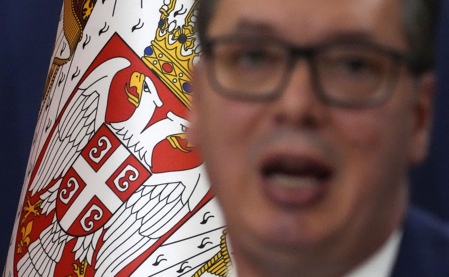 Zamagljeni portret Aleksandra Vučića pred grbom Srbije