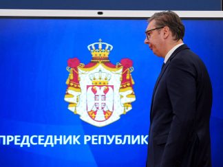 Predsednik Srbije Aleksandar Vučić slikan iz profila pred grbom Republike Srbije