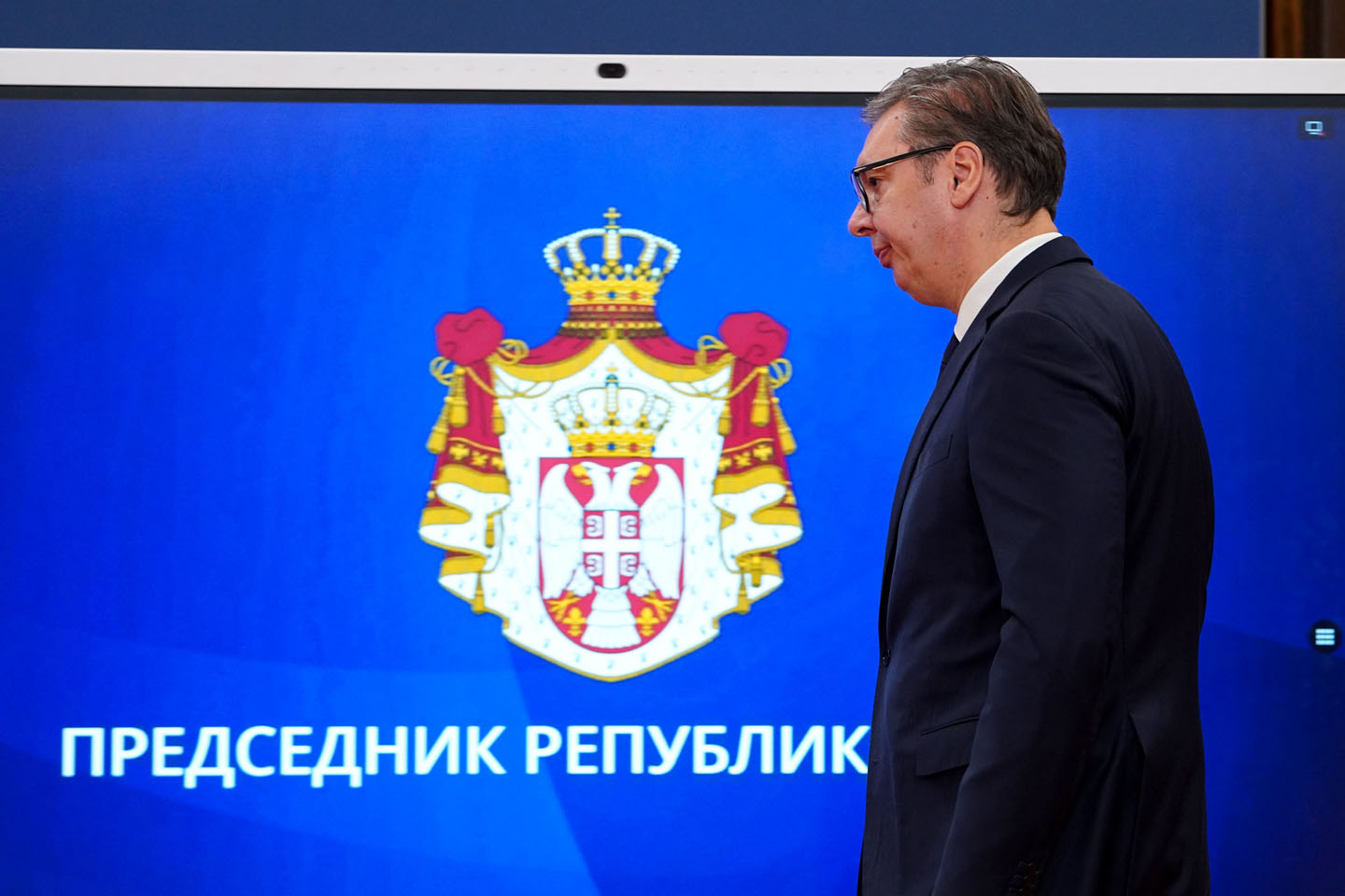 Predsednik Srbije Aleksandar Vučić slikan iz profila pred grbom Republike Srbije