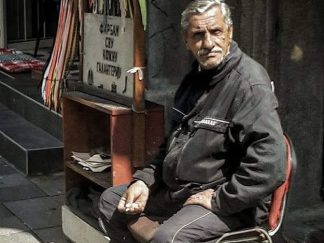 Čistač cipela Sebastian na ulici sa pertlama u pozadini