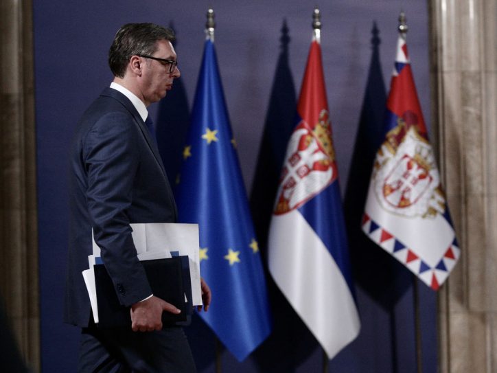 Aleksandar Vučić hoda, iza njega zastave Srbije i EU