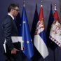 Aleksandar Vučić hoda, iza njega zastave Srbije i EU