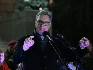 Predsednik Srbije Aleksandar Vučić u kaputu maše rukama