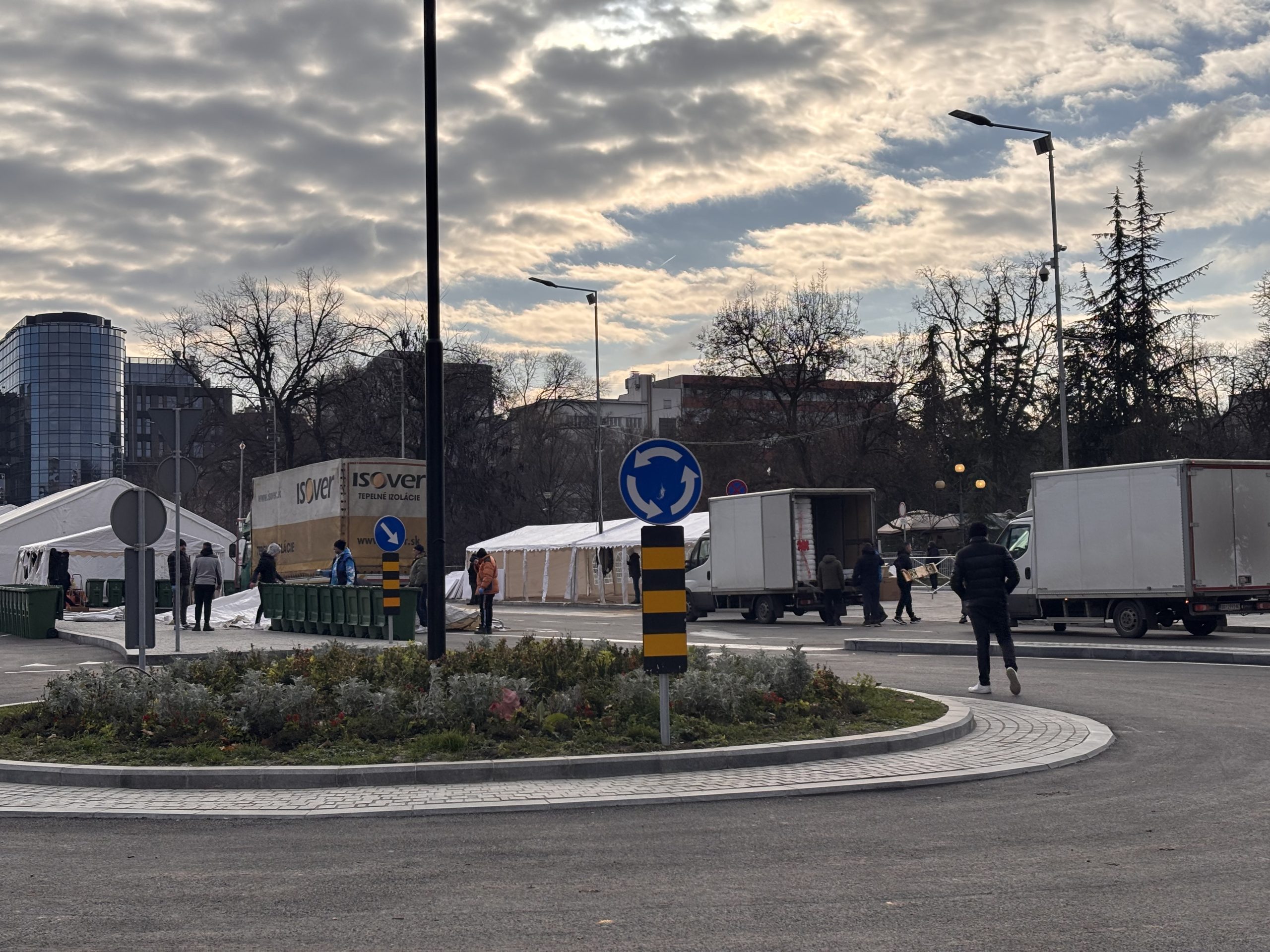 Nekoliko ljudi, beli šatori, kamioni, klupe u Ćacilendu