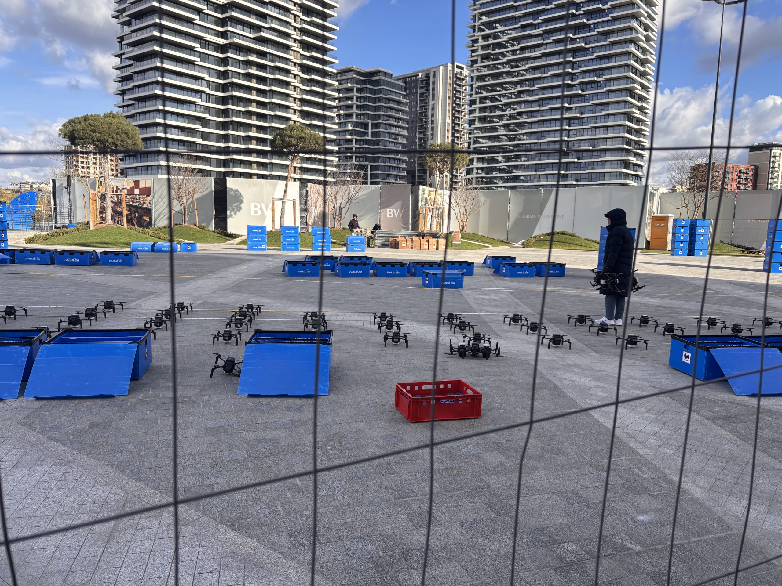 Dronovi u beogradu na vodi na betonu, zgrade u pozadini