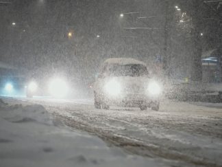 Vozilo na ulici dok sneg veje