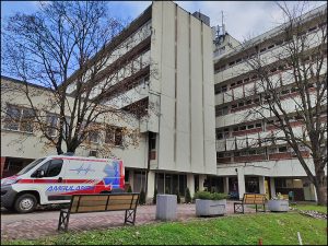 Ambulatno vozilo parkirano ispred sive zgrade.