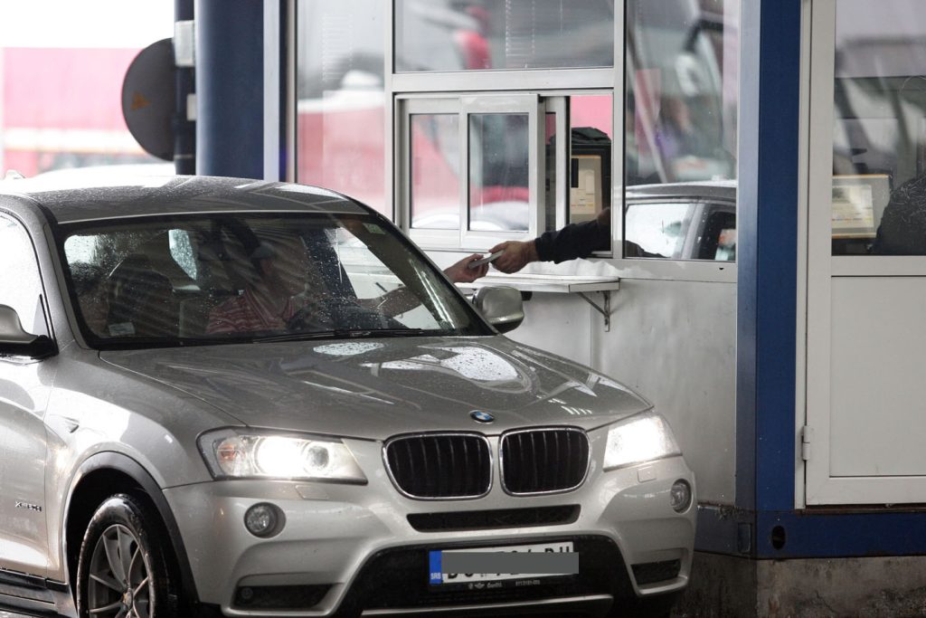 Automobil na granici, vozač pruža pasoš graničaru