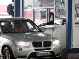 Automobil na granici, vozač pruža pasoš graničaru