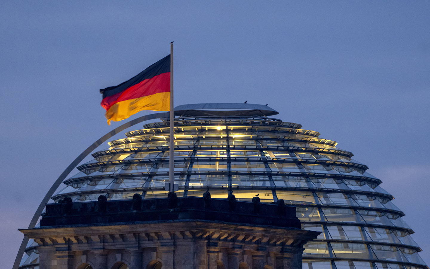 Nemačka zastava vijori se a u pozadini je staklena kupola i plavo nebo