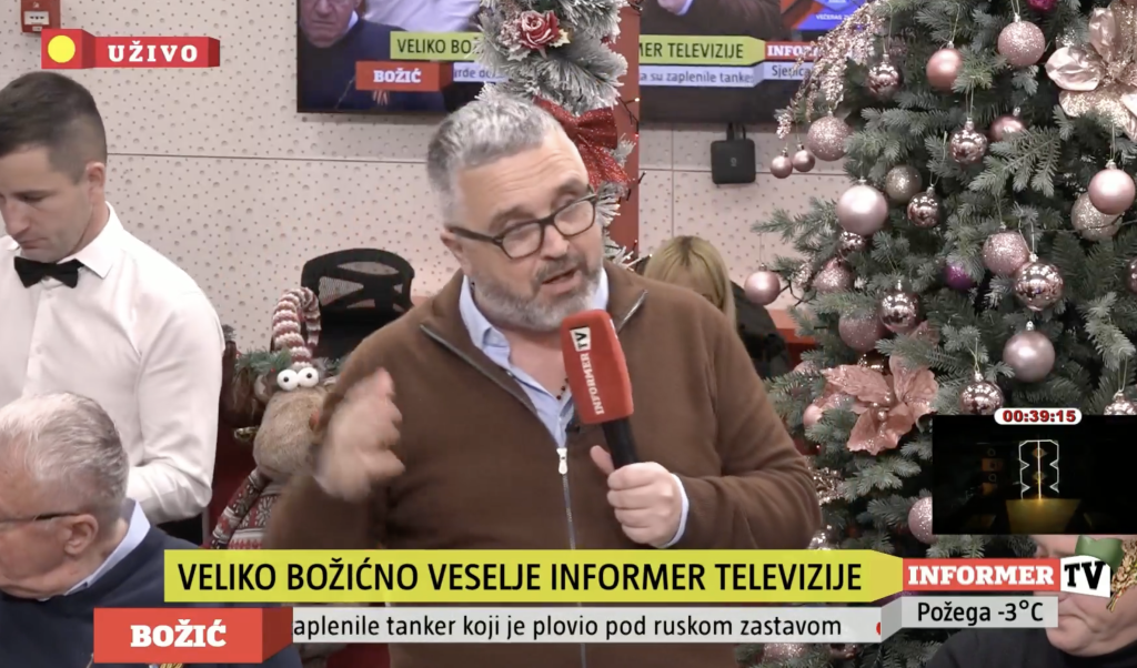 Dragan J. Vučićević drži mikrofon i priča na proslavi Božića u studiju