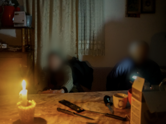 Dvoje penzionera na kauču, na stolu upaljena sveća