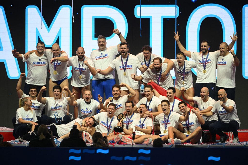 Grupa muškaraca slavi i pozira sa sportskim medaljama