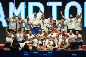 Grupa muškaraca slavi i pozira sa sportskim medaljama