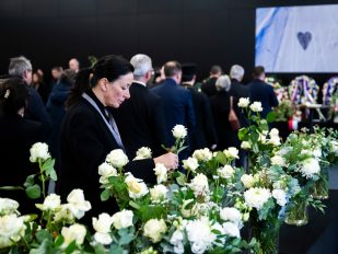 Žena tuguje i polaže sveće