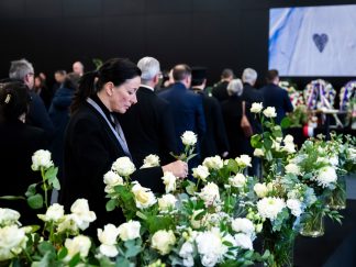 Žena tuguje i polaže sveće