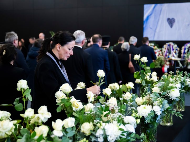 Žena tuguje i polaže sveće