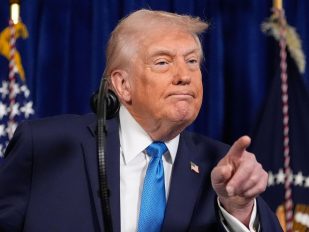 Predsednik SAD Donald Tramp sa svetloplavom kravatom upire prst u publiku