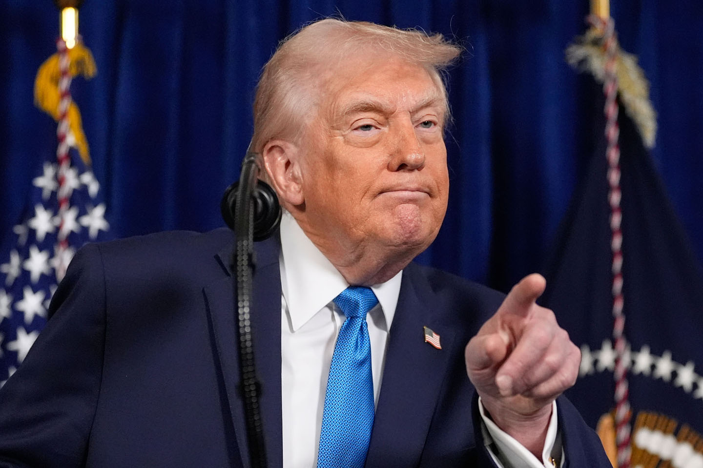 Predsednik SAD Donald Tramp sa svetloplavom kravatom upire prst u publiku