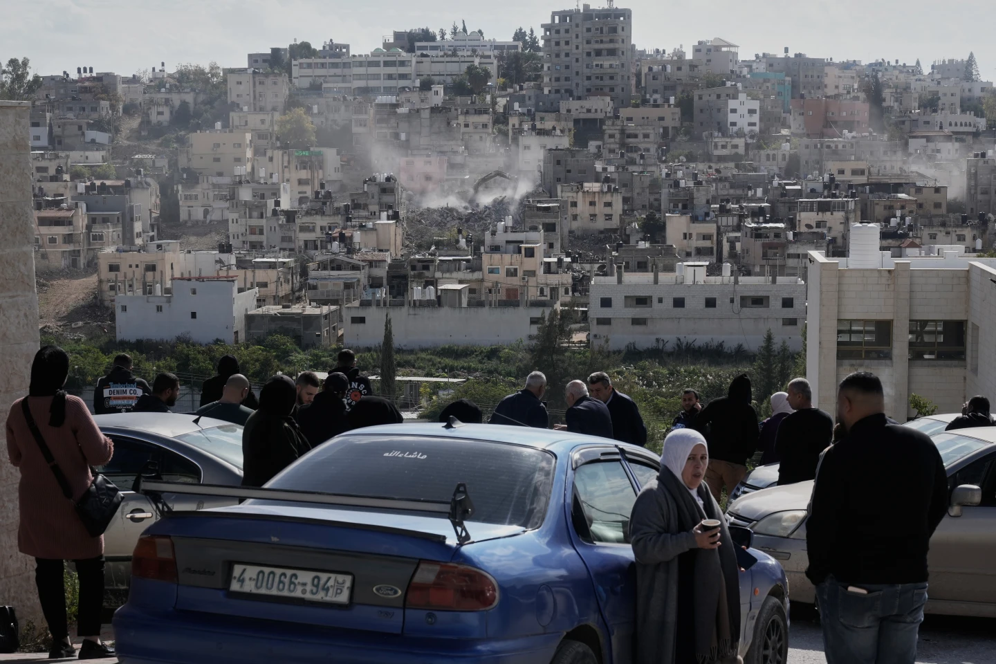 Ljudi posmatraju kako izraelski vojni buldožer ruši kuće u palestinskom izbegličkom kampu Nur Šams, blizu grada Tulkarema na Zapadnoj obali.