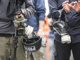 Dvojica novinara s gas maskama i šlemovima