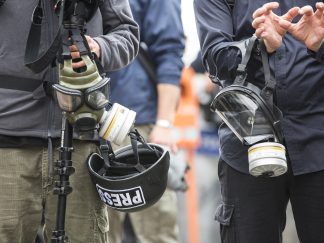 Dvojica novinara s gas maskama i šlemovima