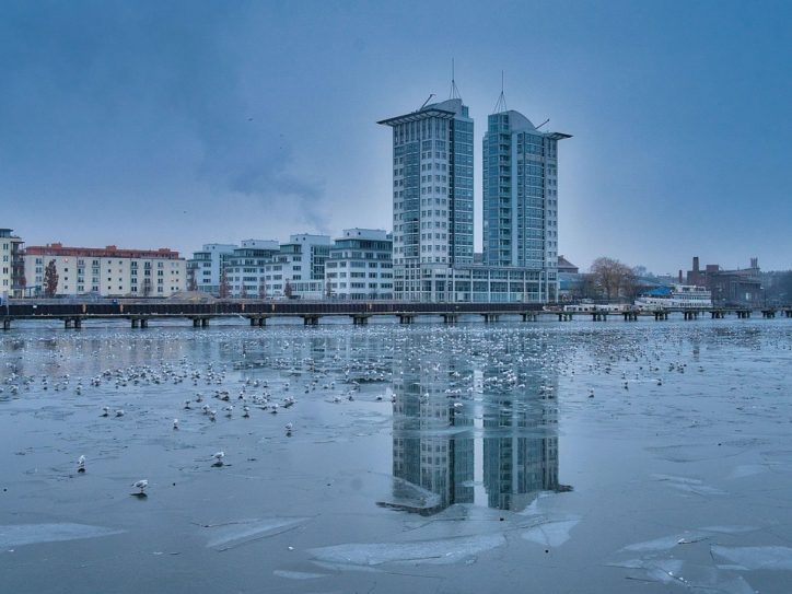 Odsjaj dva solitera na zaleđenom jezeru na kome se nalaze ptice