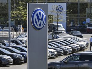 Brojna vozila Folksvagena na parkingu fabrike i veliki logo VW