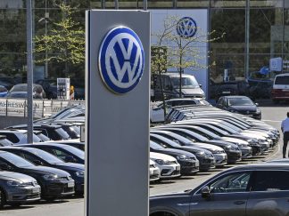 Brojna vozila Folksvagena na parkingu fabrike i veliki logo VW