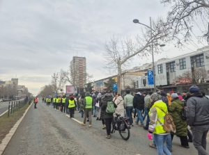 Ljudi u koloni idu kolovozom