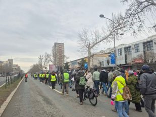 Ljudi u koloni idu kolovozom