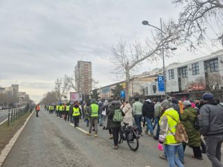 Ljudi u koloni idu kolovozom