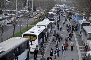 Ljudi izlaze i mnogobrojnih parkiranih autobusa