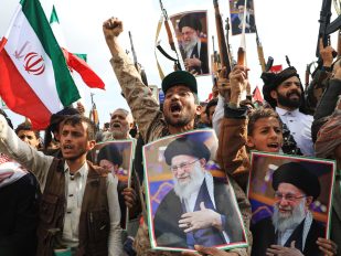 Masa ljudi sa uzdignutim pesniciama, piuškama fotografijama ajatolaha Alija Hamneija