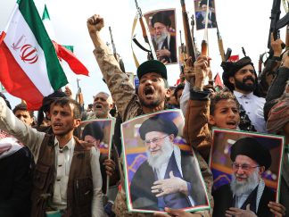 Masa ljudi sa uzdignutim pesniciama, piuškama fotografijama ajatolaha Alija Hamneija