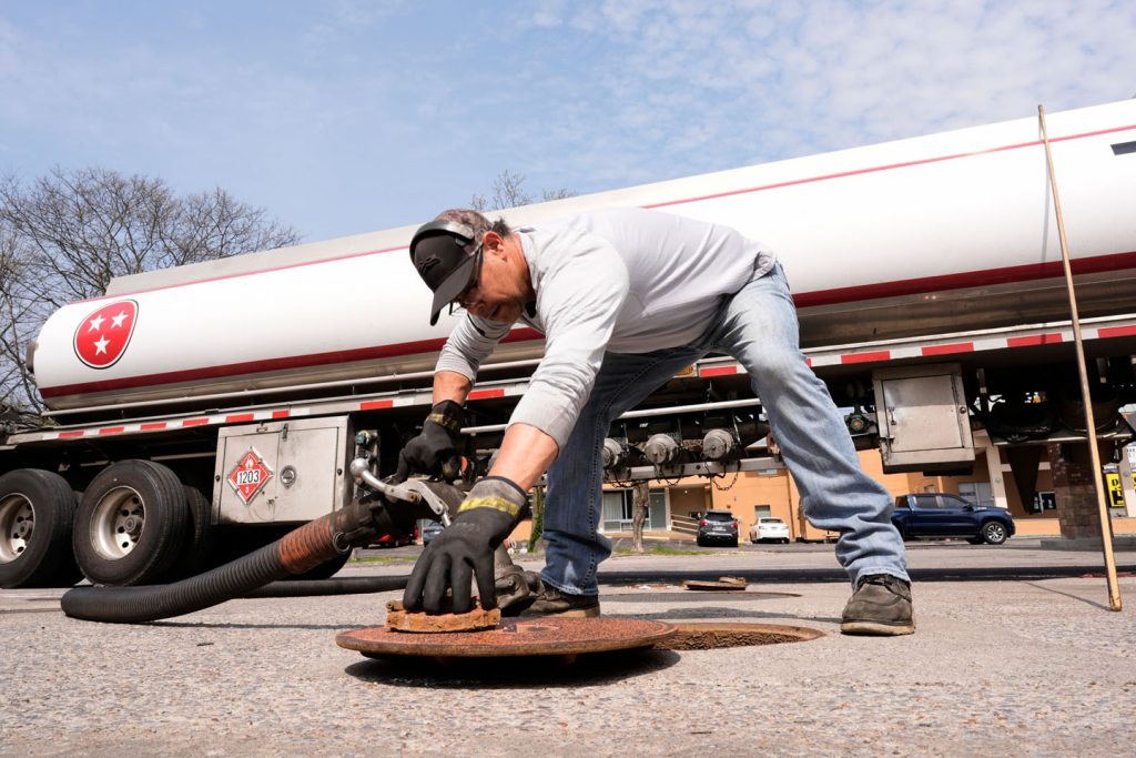Čovek zavija ventil za naftu