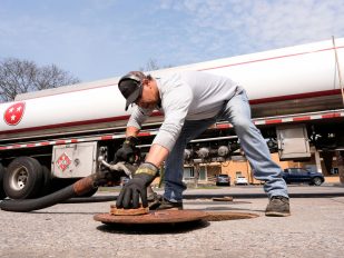 Čovek zavija ventil za naftu