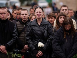 Žena plače na sahrani vojnika u Ukrajini