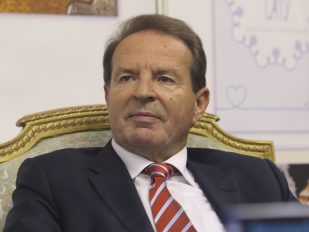 Bogoljub Karić u fotelji sa odelom i crvenom kravatom na štrafte