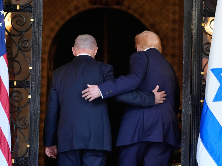 Donald Tramp i Benjamin Netanjahu, zagrljeni između zastava SAD i Izraela