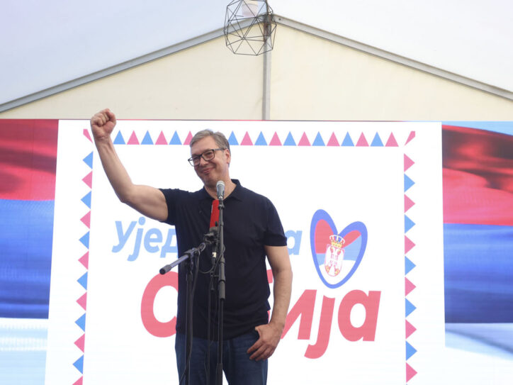 Predsednik Srbije Aleklsandar Vučić sa uzdignutom pesnicom ispred transparenta